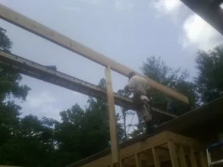 Carpenter setting a ridge beam over a new addition frame — Ice Dam Removal by Roofing Brothers in Nelson
